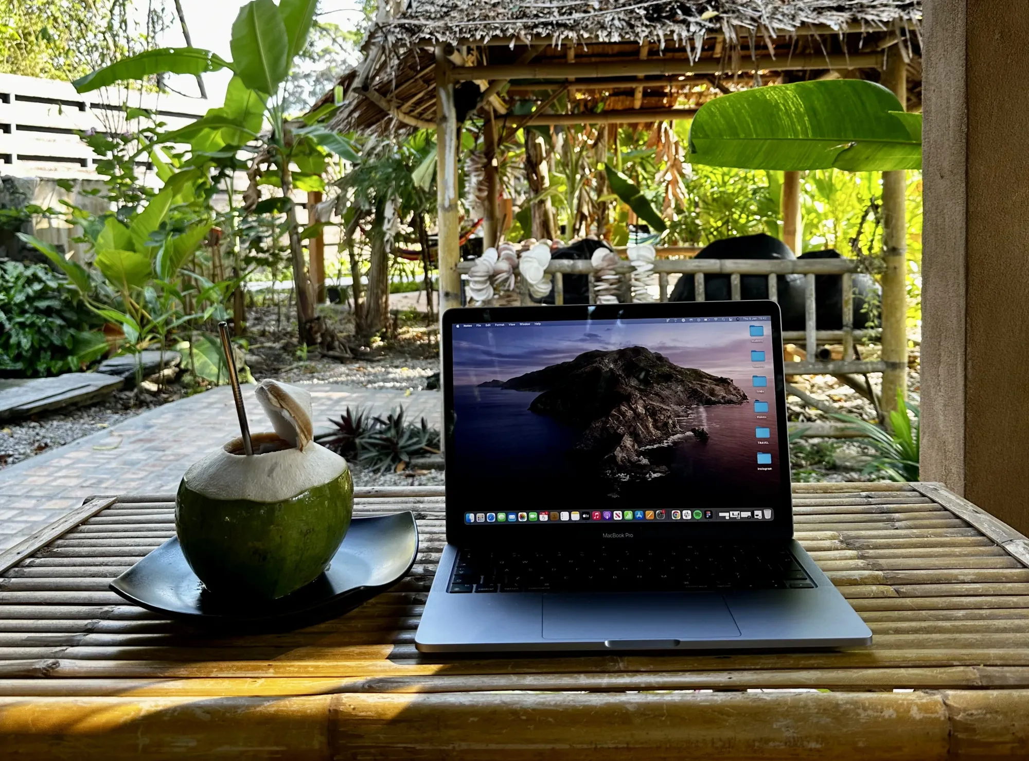Image of a laptop next to a coconut in a coworking space (Kohub) on Koh Lanta, Thailand
