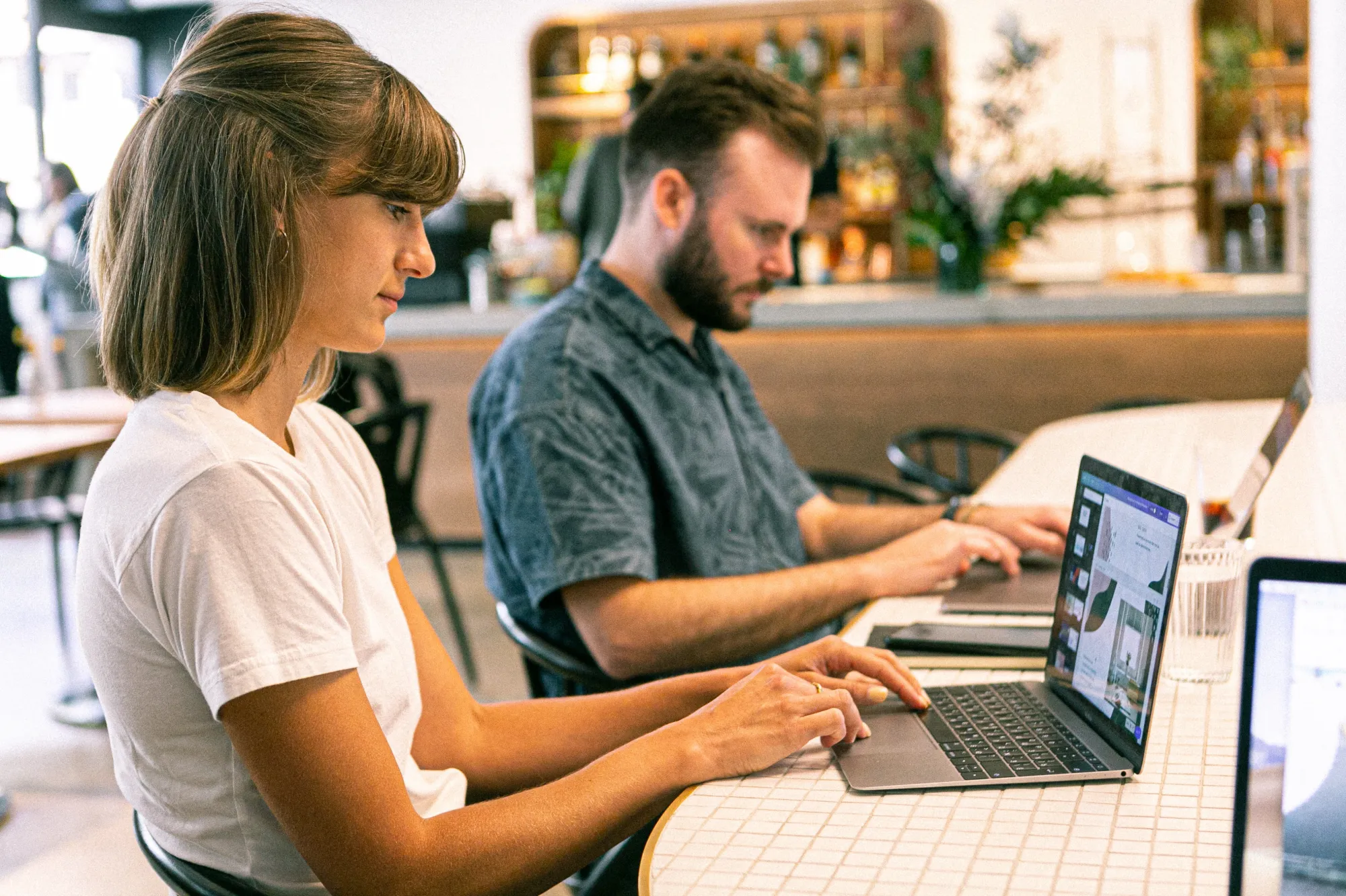 Image of two freelancers working from their laptop from a cafe