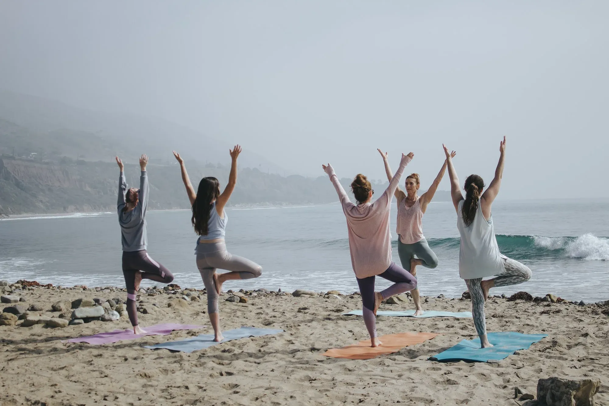 Image of people practicing yoga on the beach