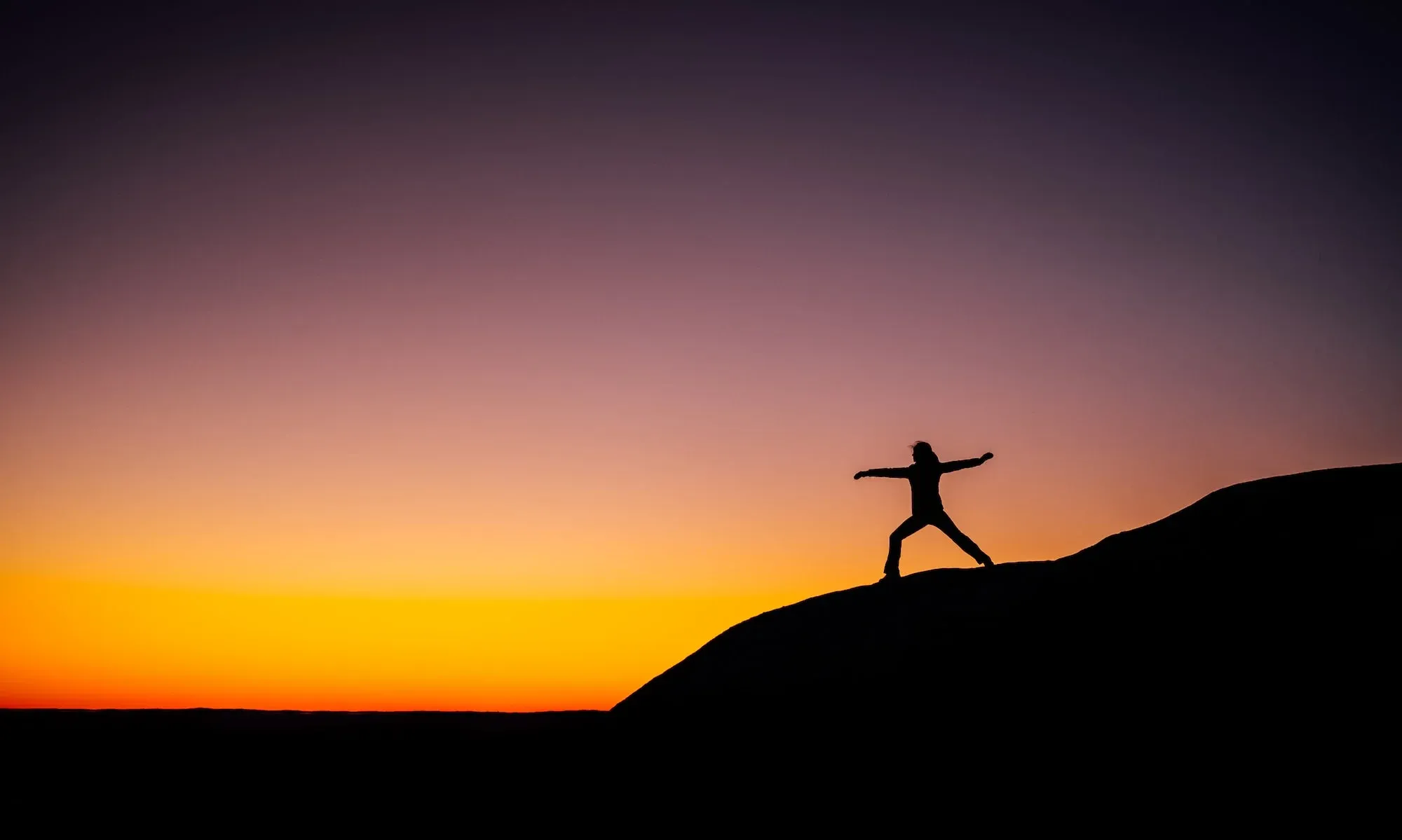 Image of a person practicing yoga at dawn