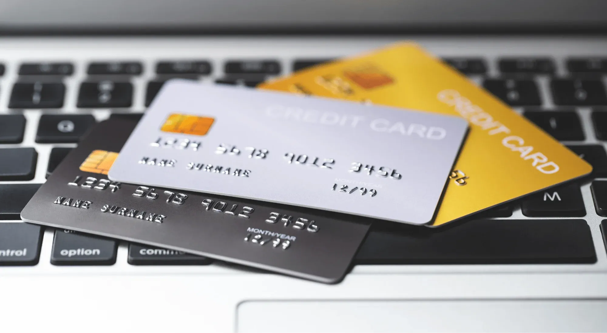 Credit cards laying on top of a laptop keyboard