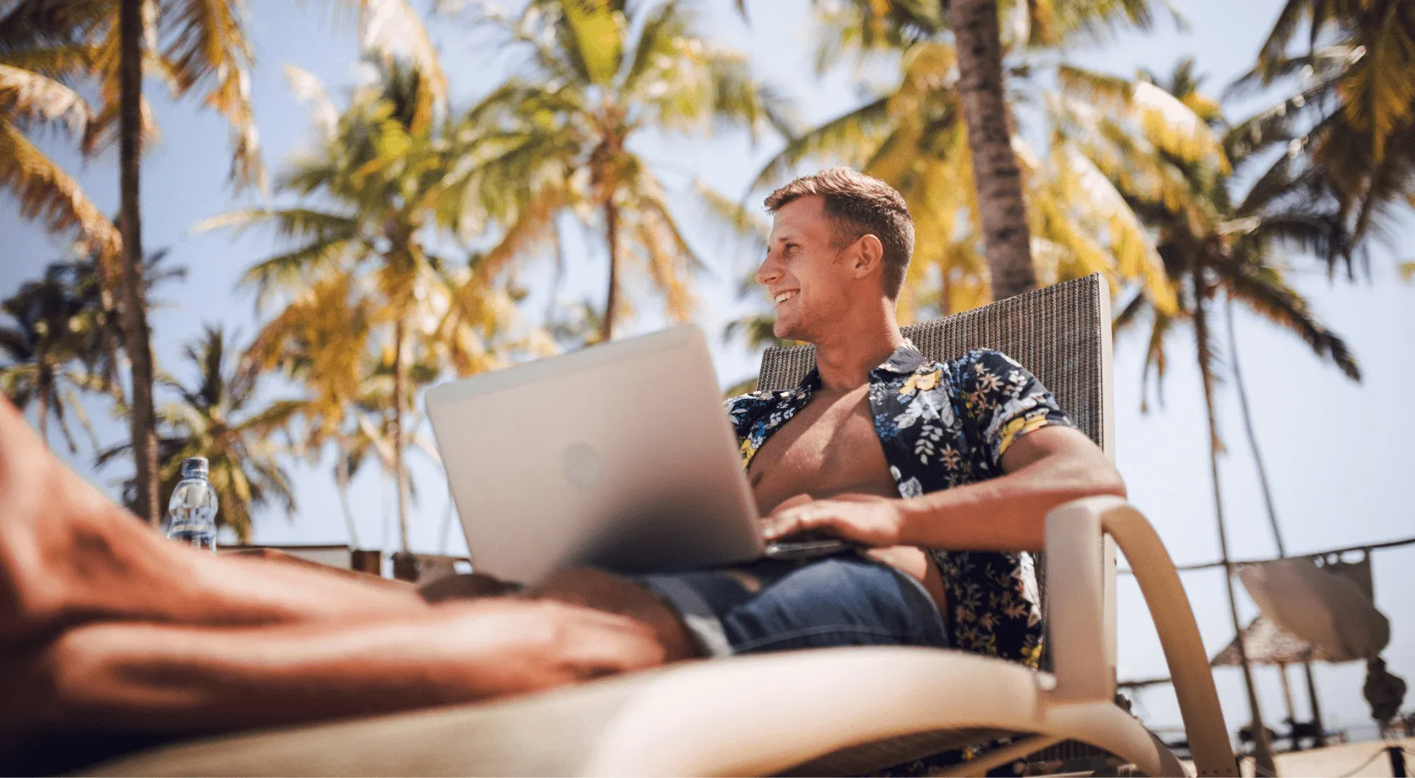 Digital nomad working from the beach with his laptop