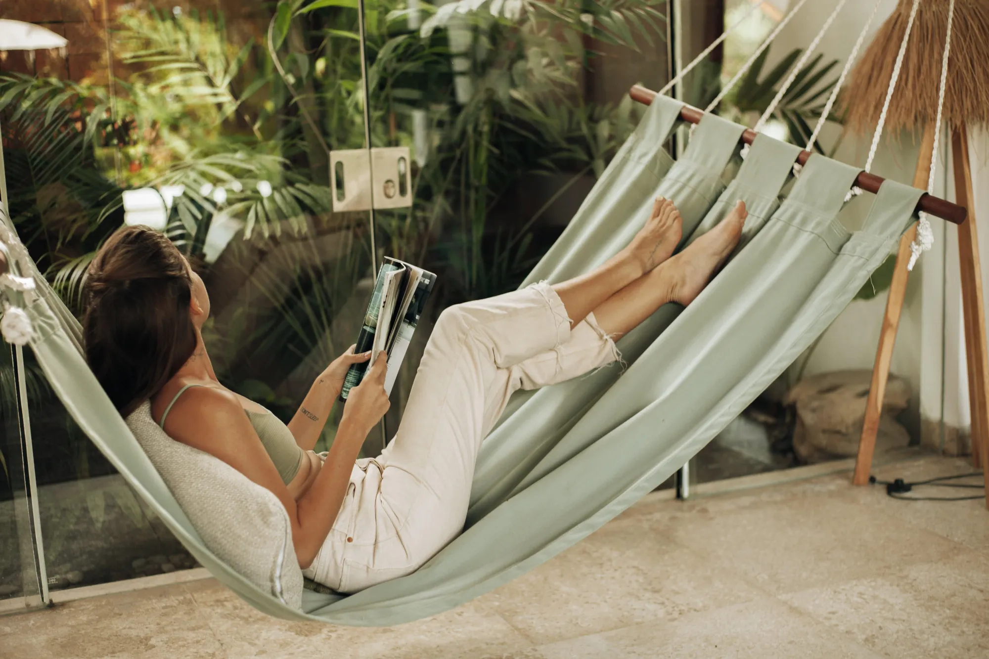 female digital nomad wearing white travel pants on a hammock