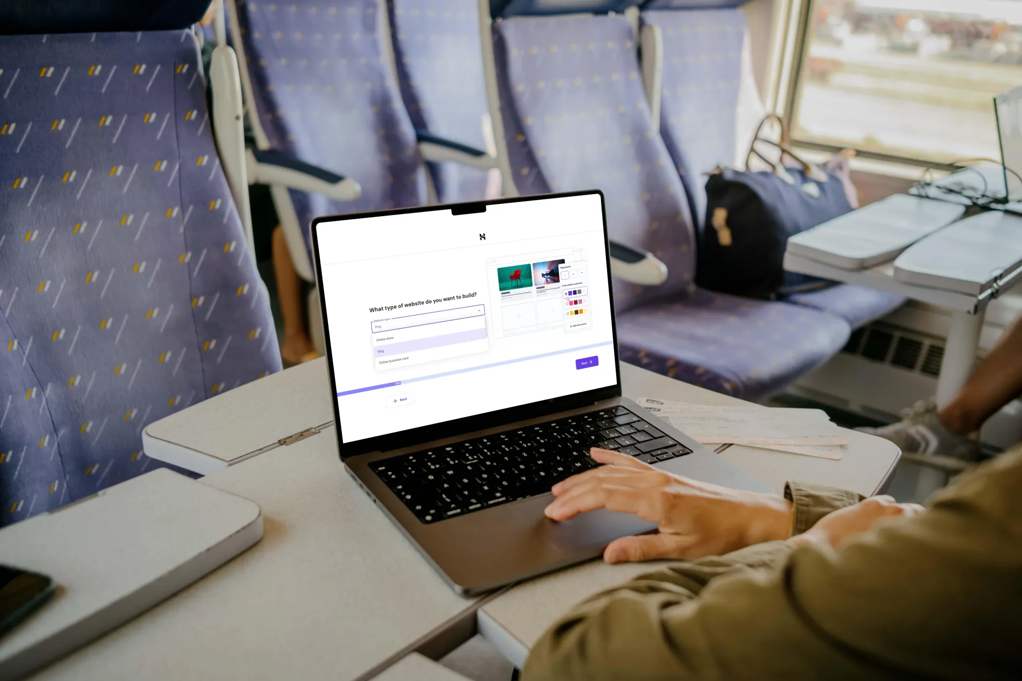 Digital nomad using Hostinger AI Website Builder on a train