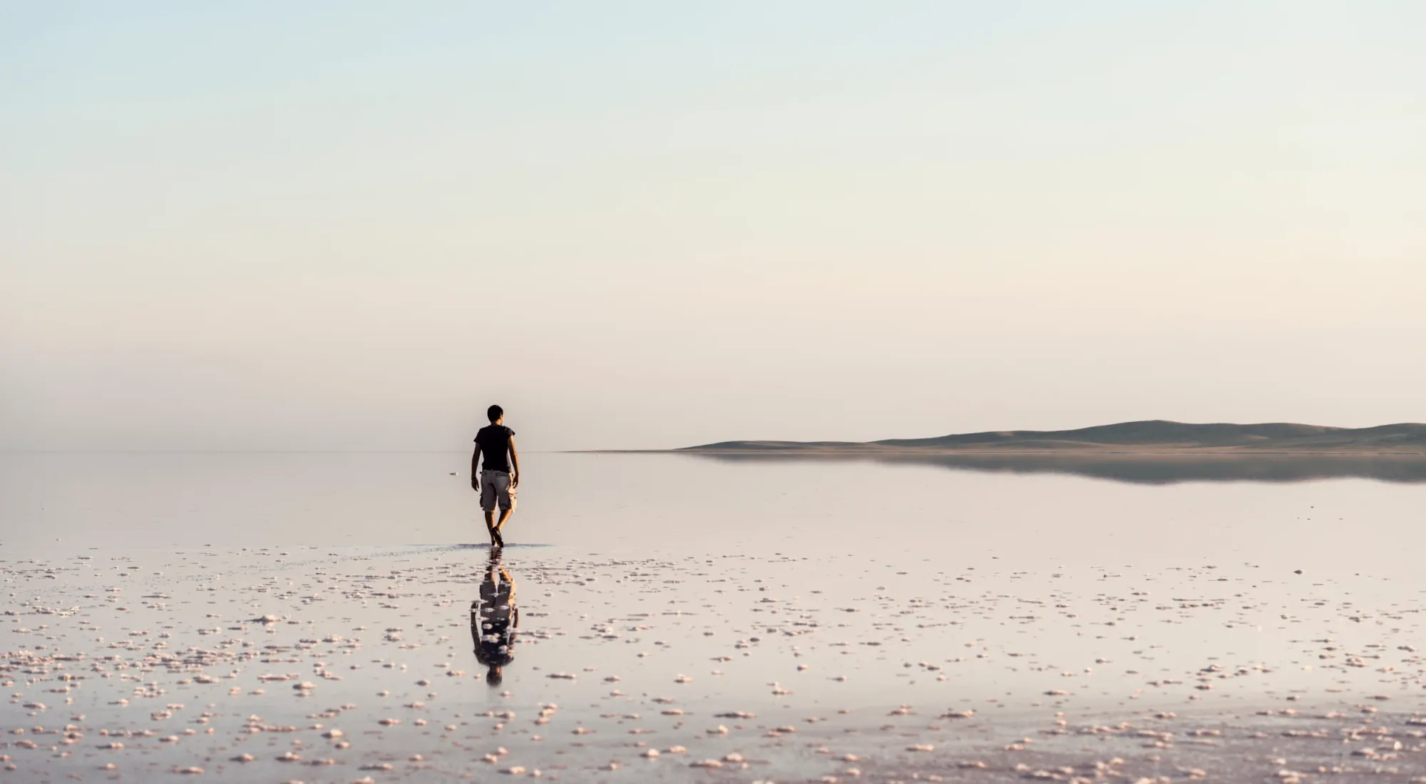 Homesick traveler near a lake at dawn