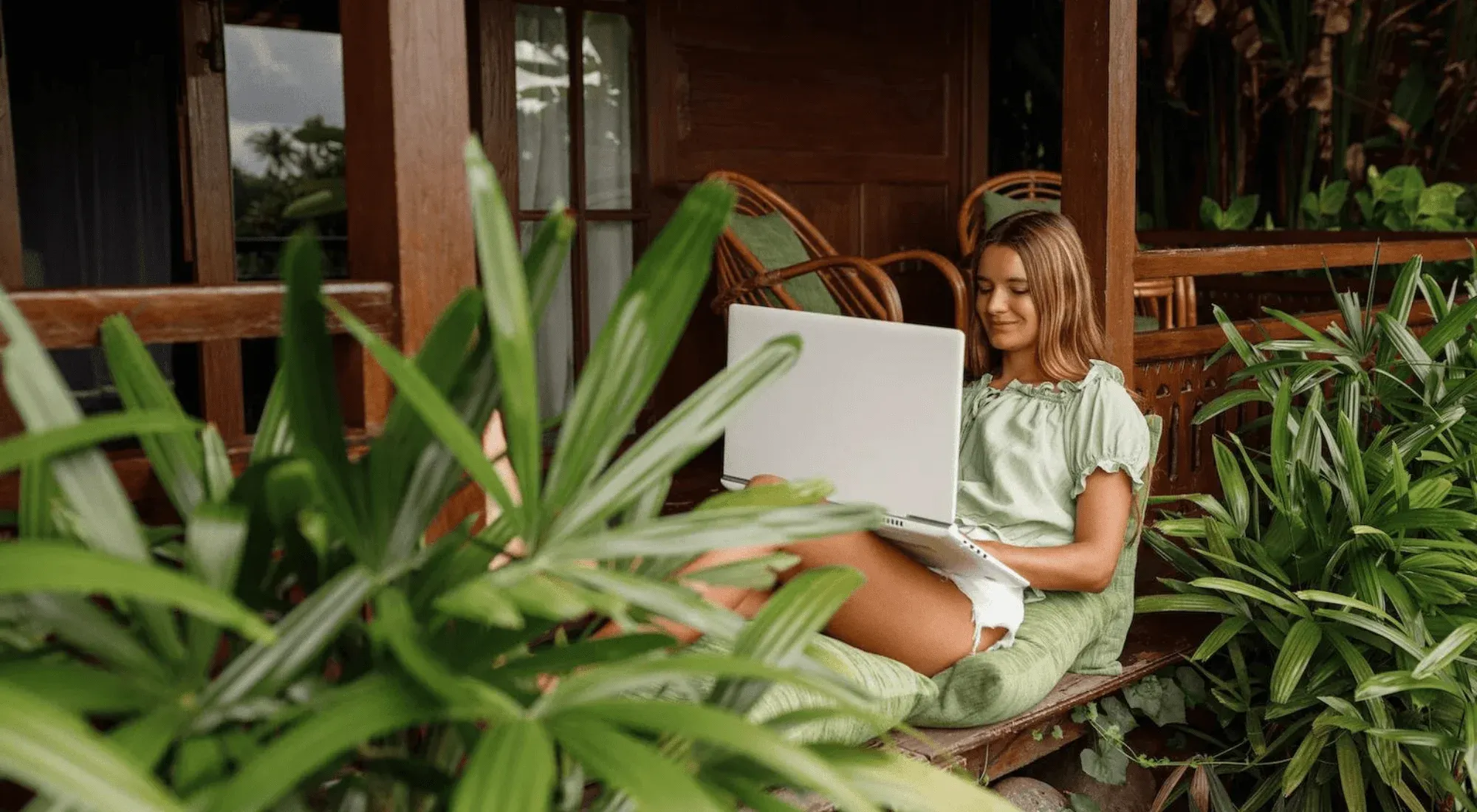 Digital nomad working from her laptop in a tropical setting