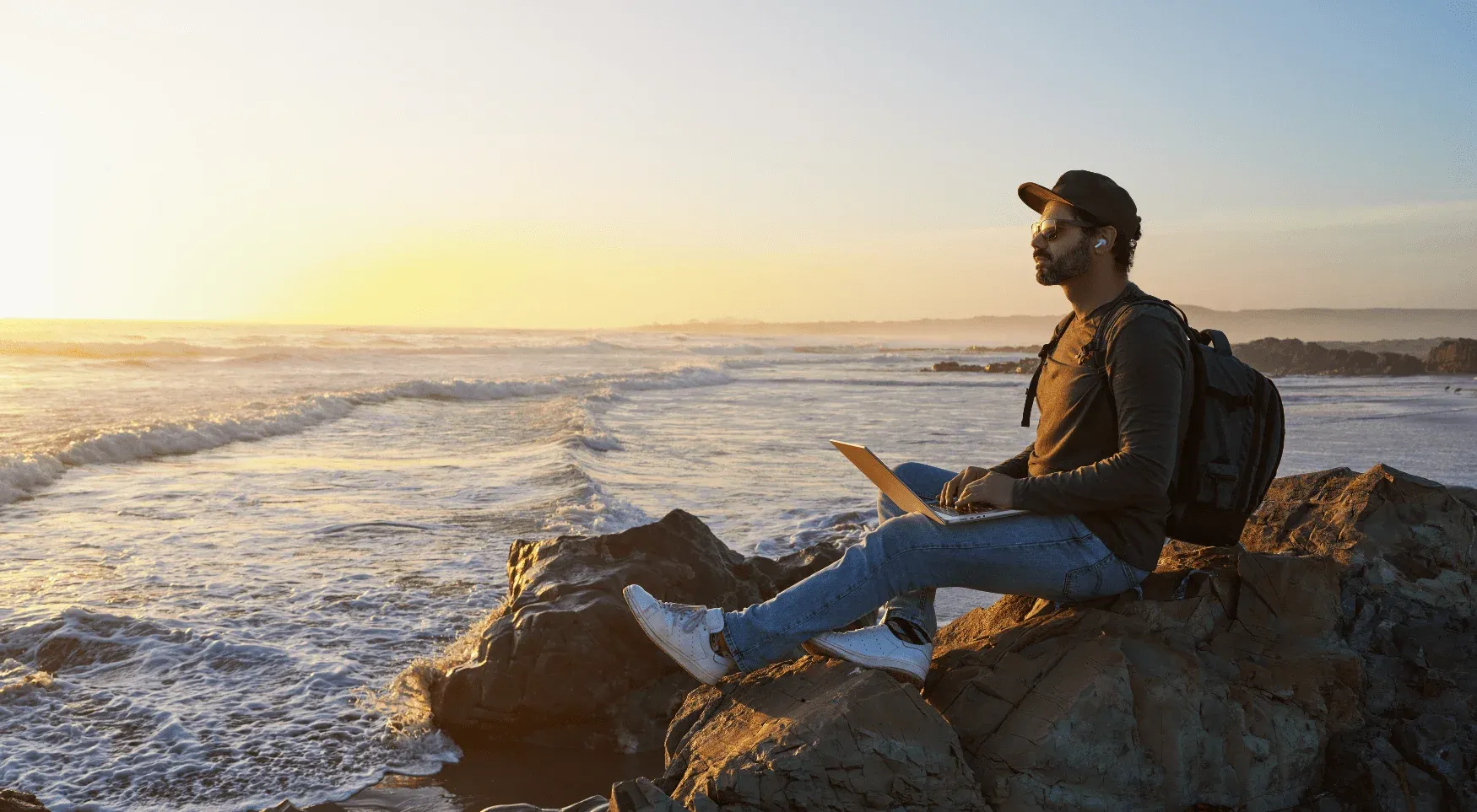 Digital nomad with a laptop at sunset