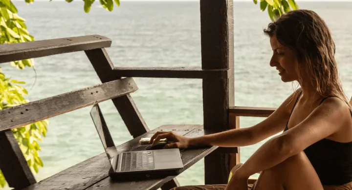 Profile of a female freelance writer and digital nomad working from the beach