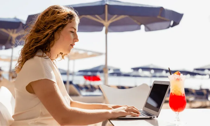 remote worker who works at the beach with her laptop
