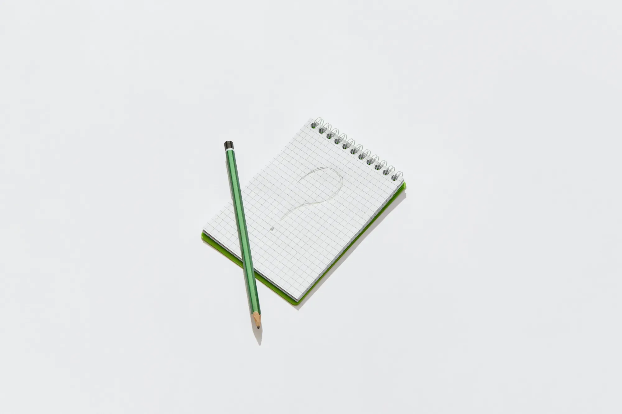 un punto interrogativo disegnato su un taccuino ed una matita