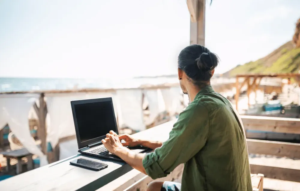 Nomade digitale che lavora fronte spiaggia