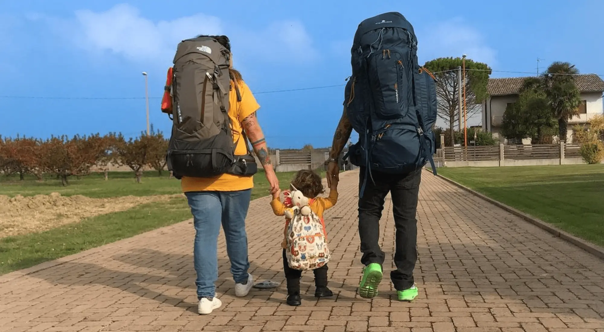 Famiglia di nomadi digitali con figli con zaino in spalla