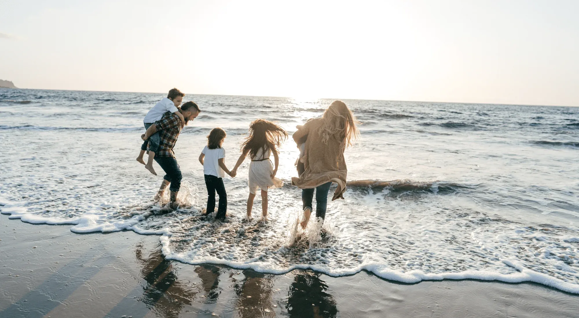 Famiglia di nomadi digitali con figli sulla spiaggia