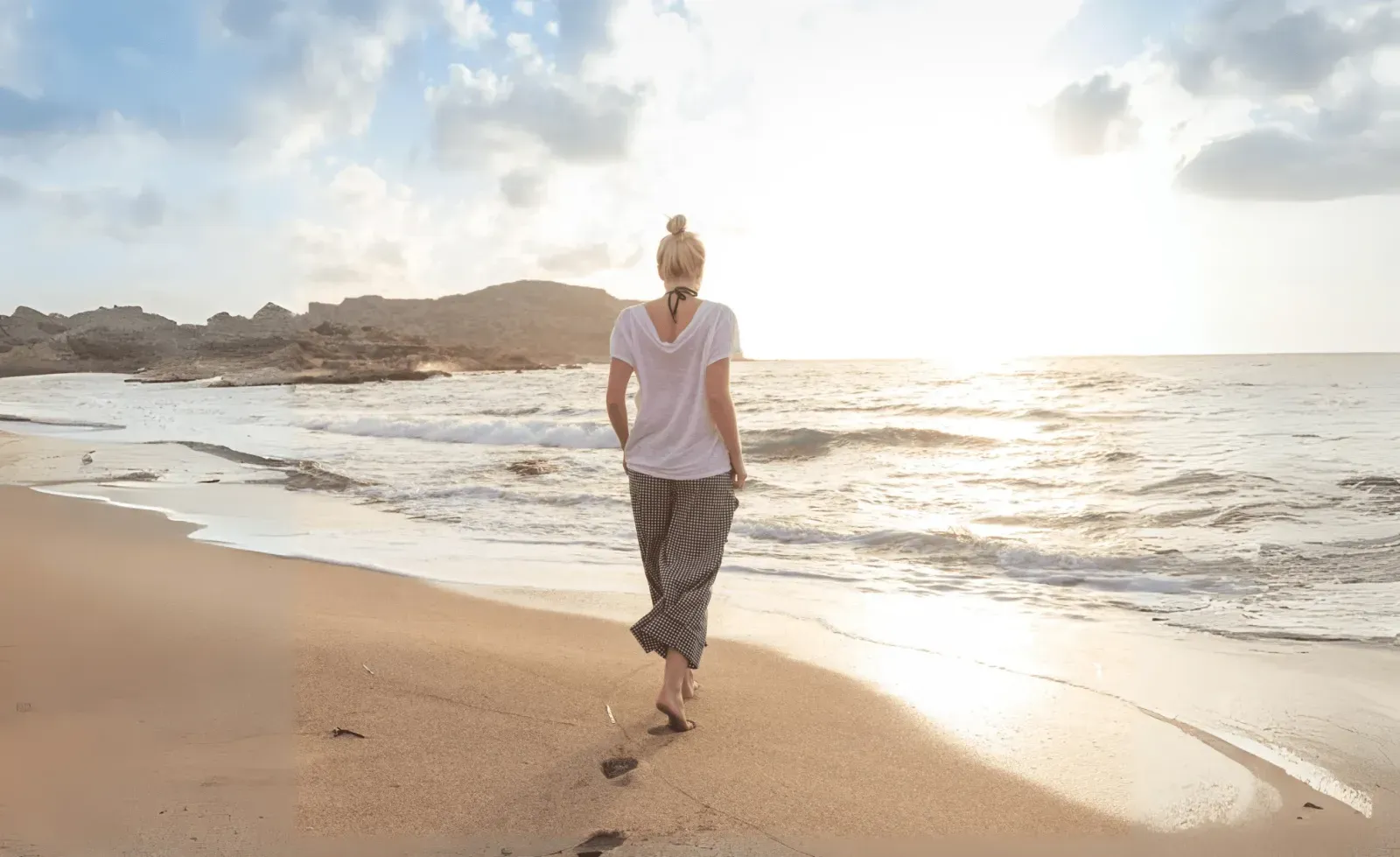 nomade digitale che fa una passeggiata sulla spiaggia